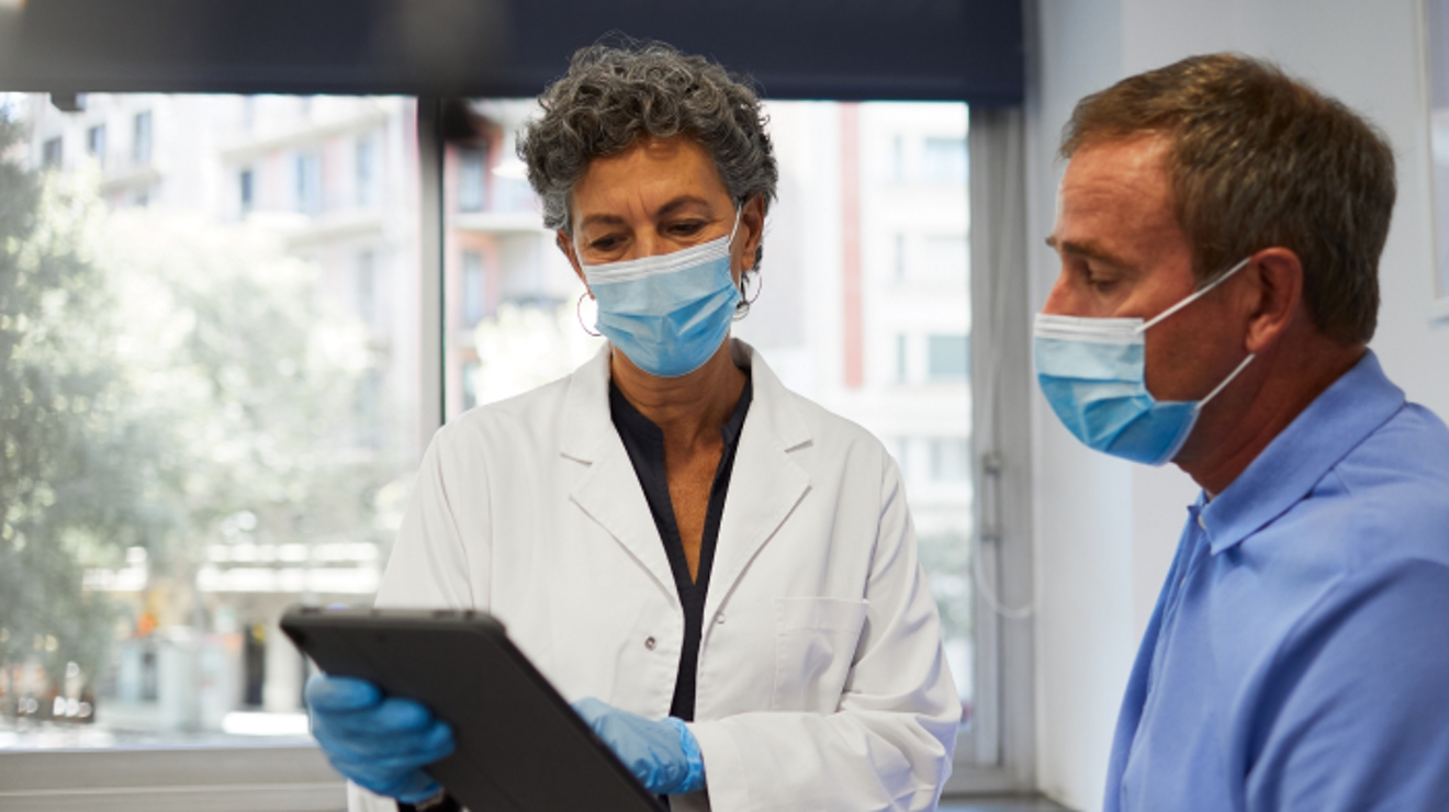 A VA physician discusses the information on her tablet with a patient.