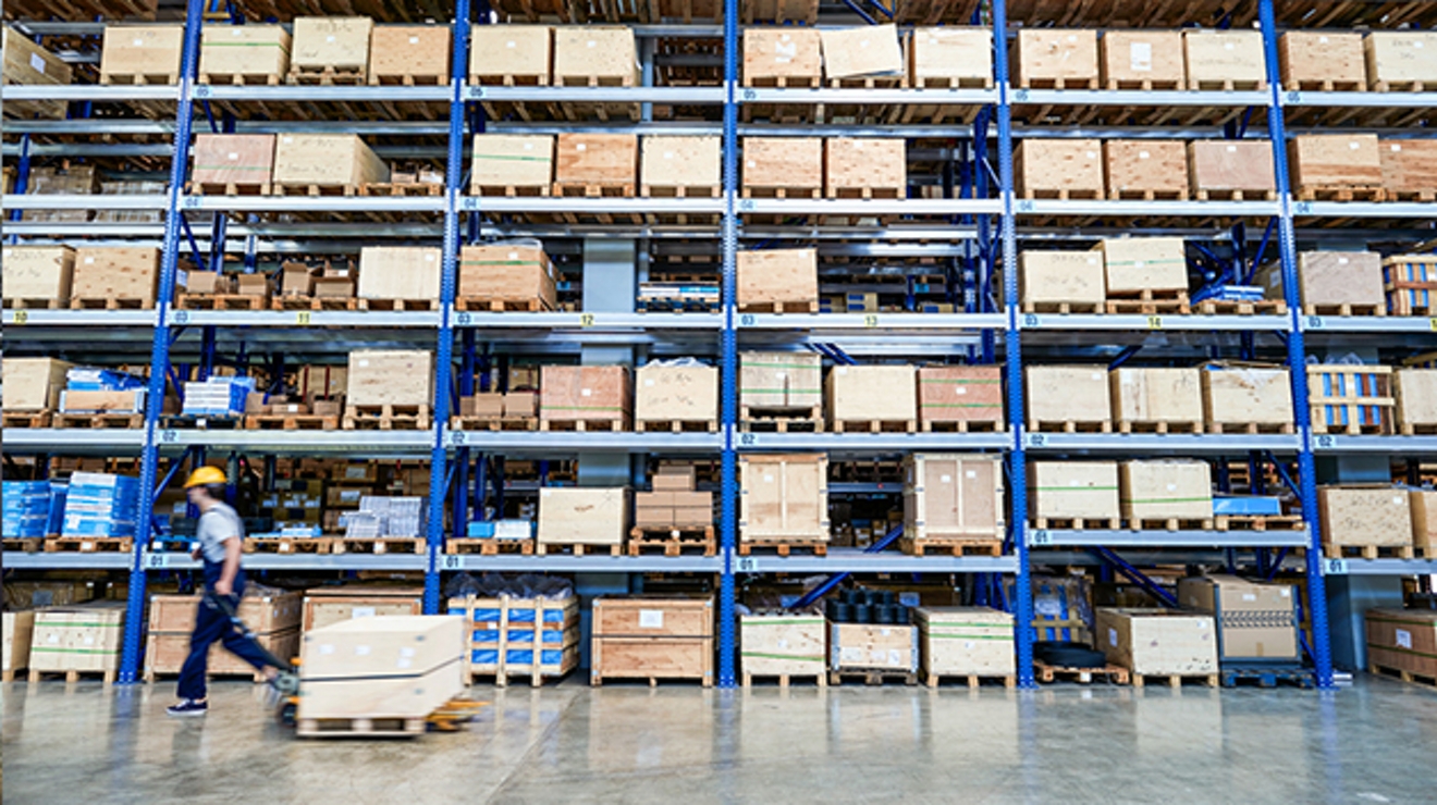 Employee hauling a pallet through a warehouse.
