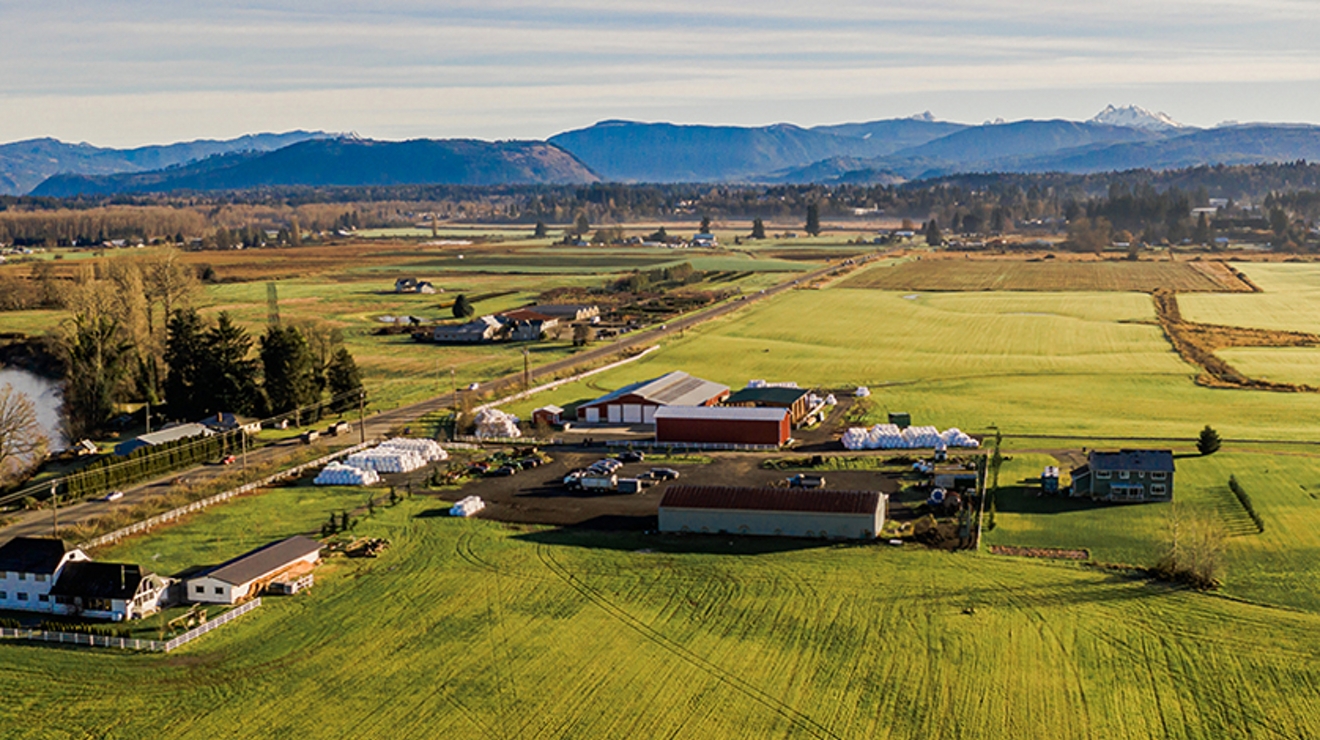 Overhead view of farm and fields with mountains in the background