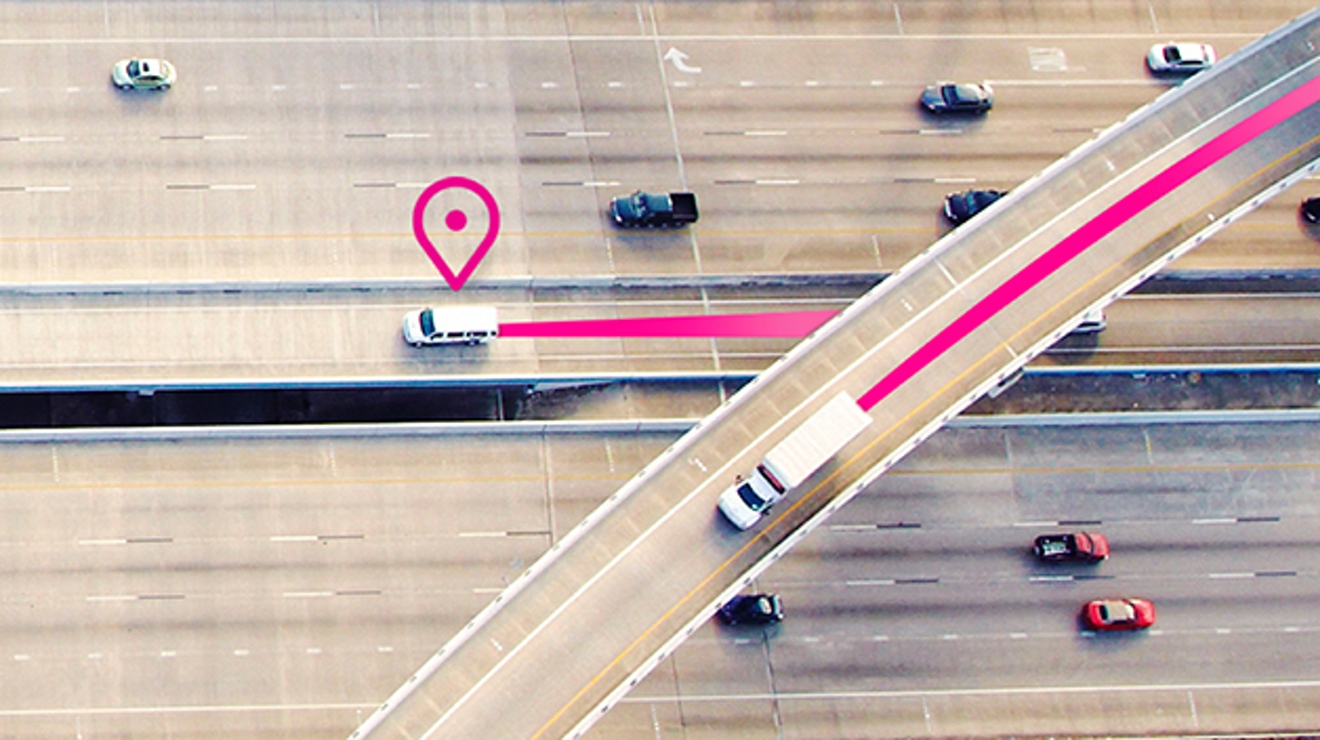 Overhead view of two white trucks on the highway with a location icon and magenta lines in back of vehicles