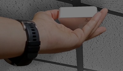 Hand holding a white monitor