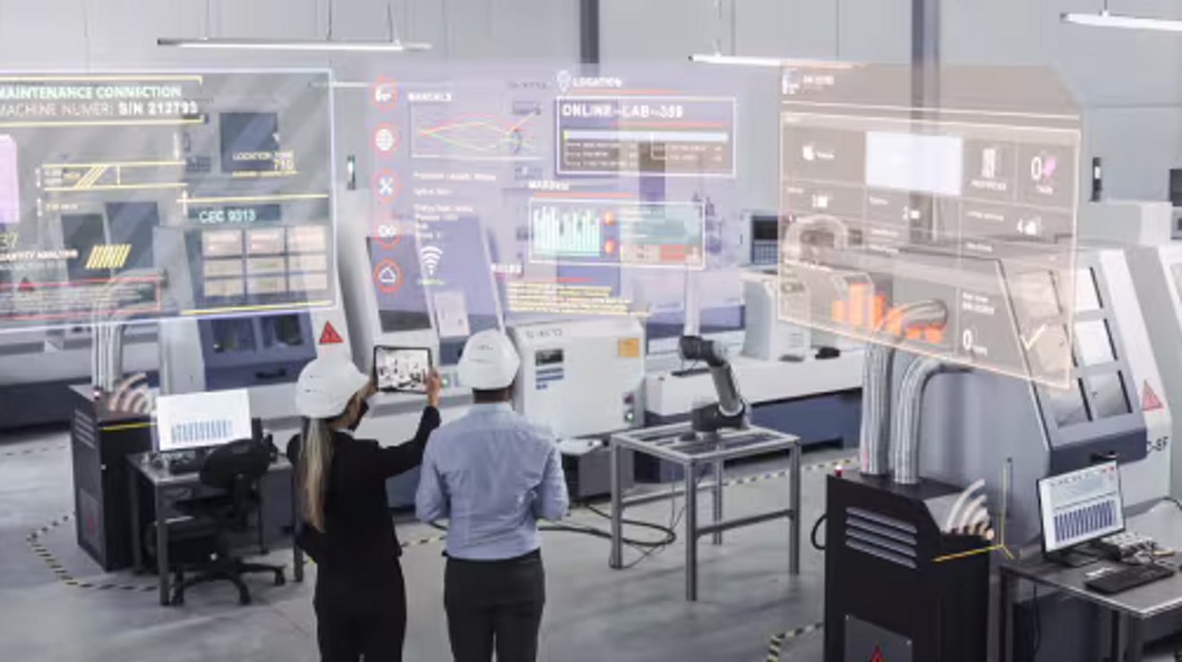 Two technicians in white safety helmets use a tablet and AR to examine sensor data on IoT-connected equipment.