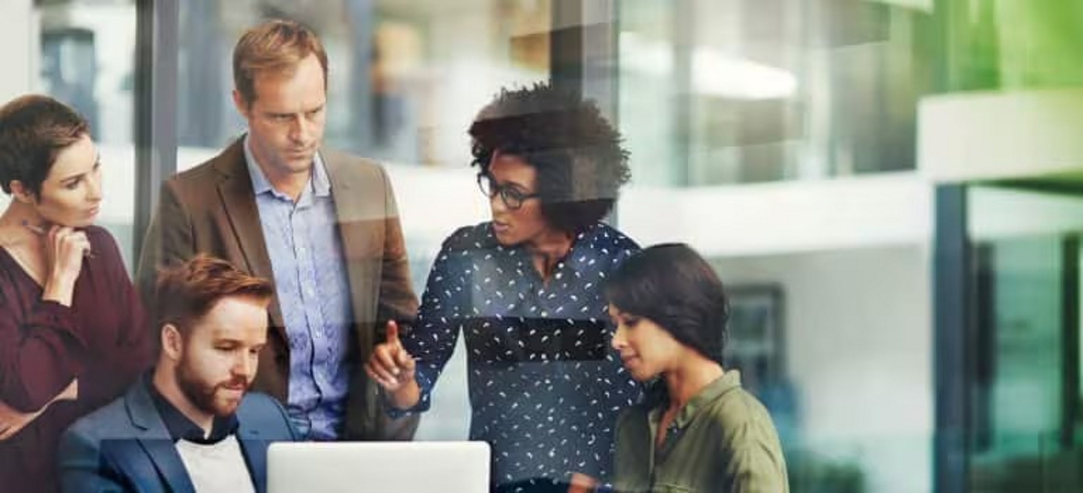 A group of coworkers confer inside an office.