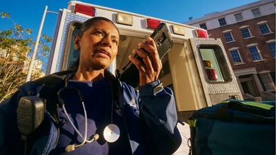 A police officer uses a cellphone enabled with Direct Connect, a push-to-talk service. 