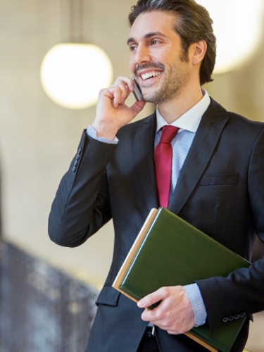 A smiling lawyer talks on his cell phone in a courthouse.