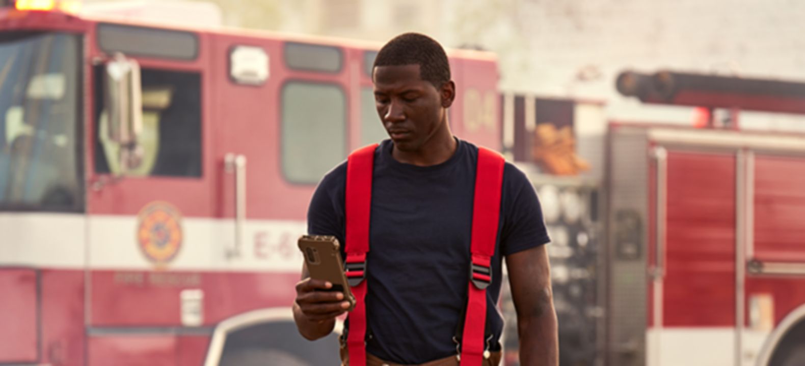 fireperson using device in front of firetruck
