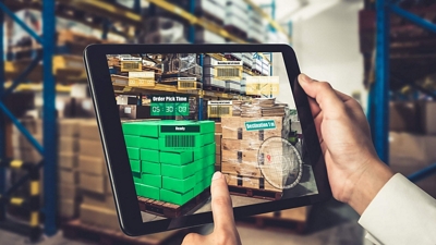 A warehouse worker sees an augmented reality view of a palette of products on their tablet.