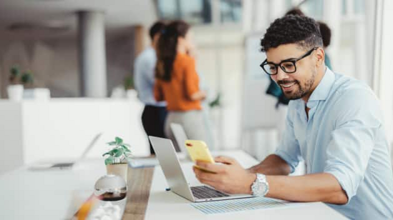 Young professional browsing on his phone in a office setting