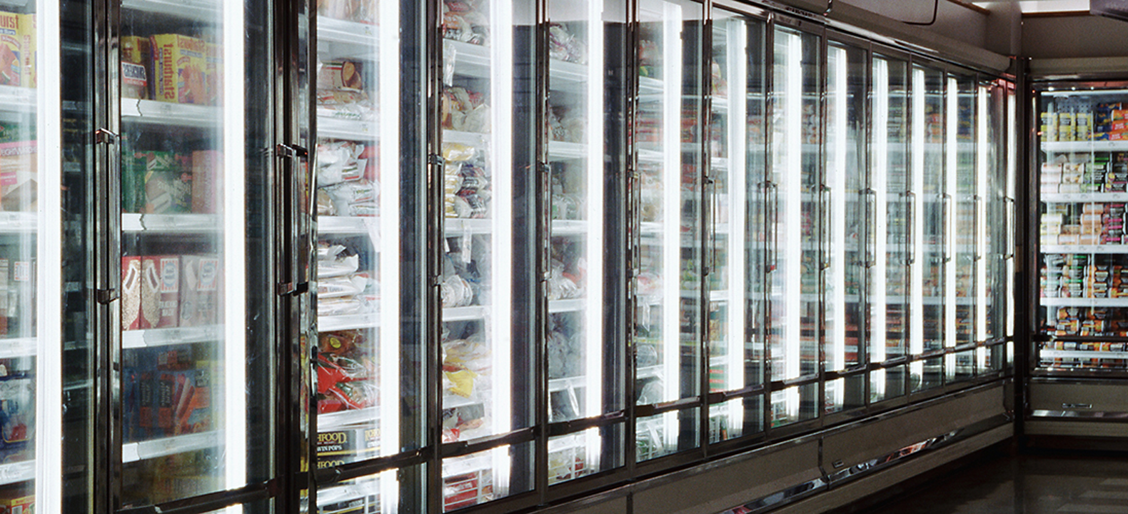 Rows of glass refrigerator/freezer units with inventory inside