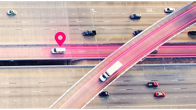 Aerial view of highway with magenta lines and location icon.