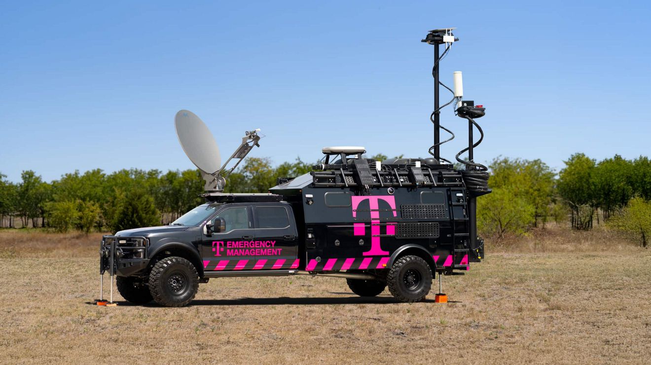 A T-Mobile emergency management truck in the wilderness with satellite dish and other gear in use. 