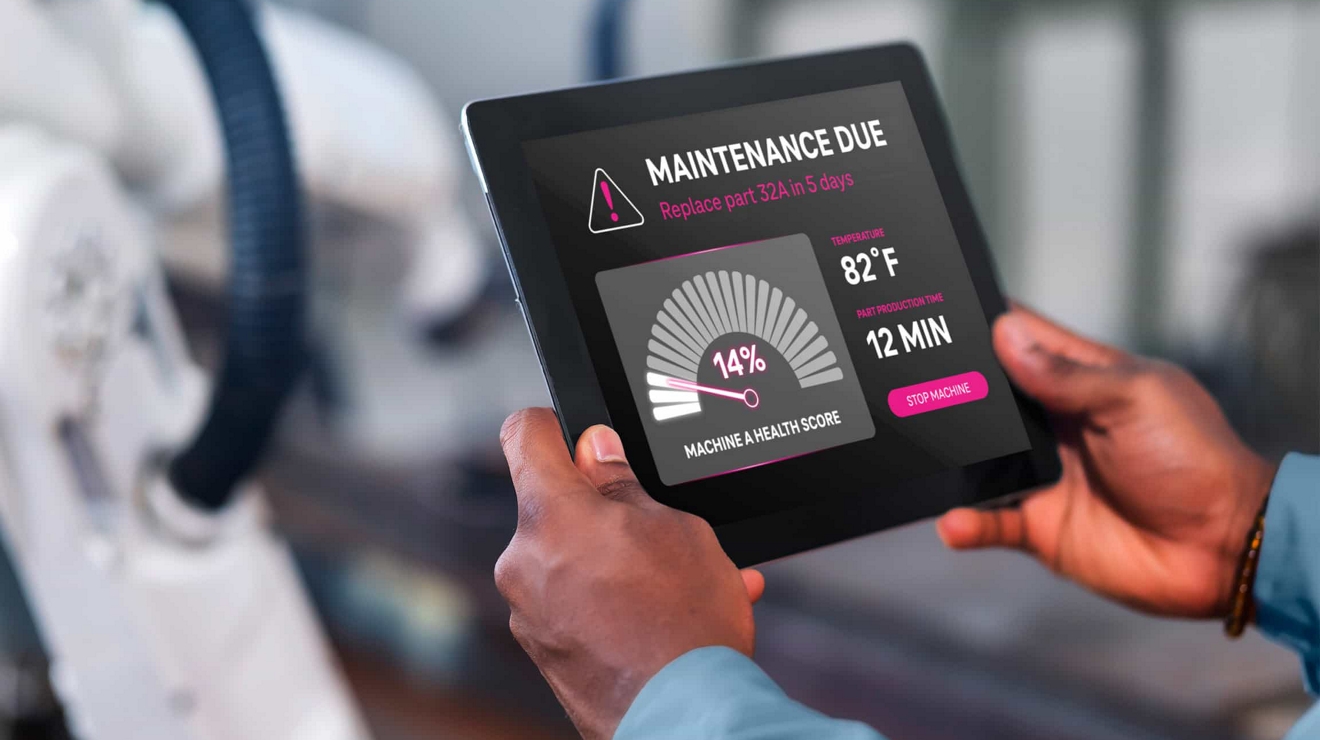 Manufacturing plant worker uses a tablet to review a maintenance status update for some equipment.