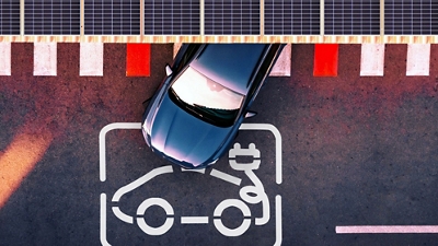 Aerial view of an electric vehicle at a parking lot charging station.