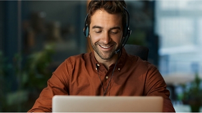 A government employee uses their headset during a video call on a laptop.