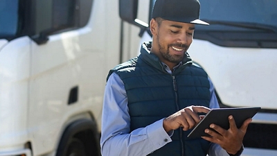 A delivery worker reviews information on his 5G-connected tablet.