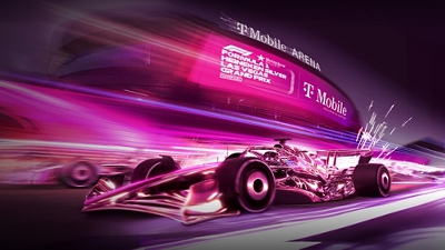 A magenta Formula 1 car racing on a magenta track outside the T-Mobile Arena.