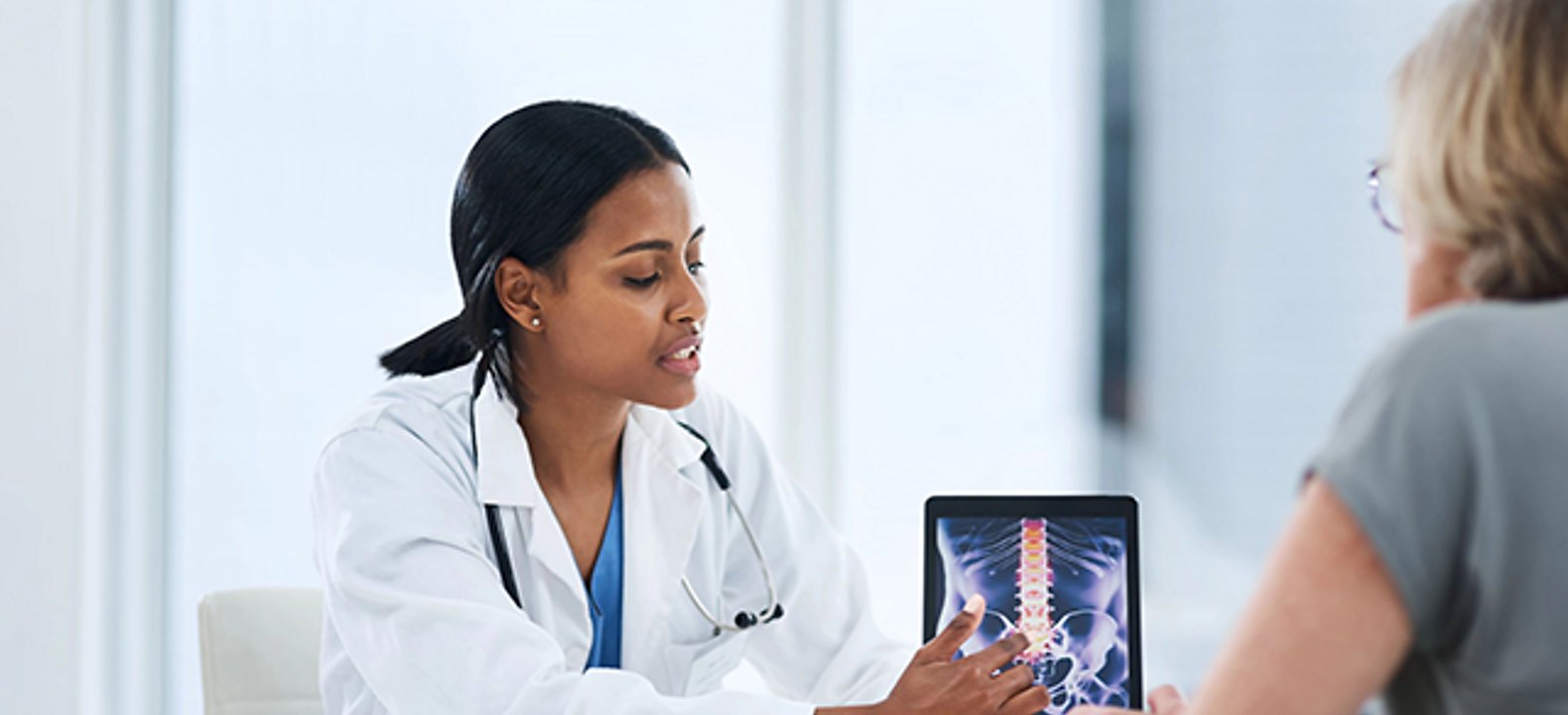 doctor consulting with patient using tablet to show xray