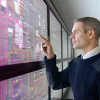 A man working on a digital component covered by a glass surface