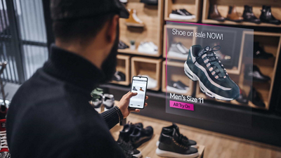 An a shoe shopper checks the retailer’s website on his smartphone while shopping in store. 