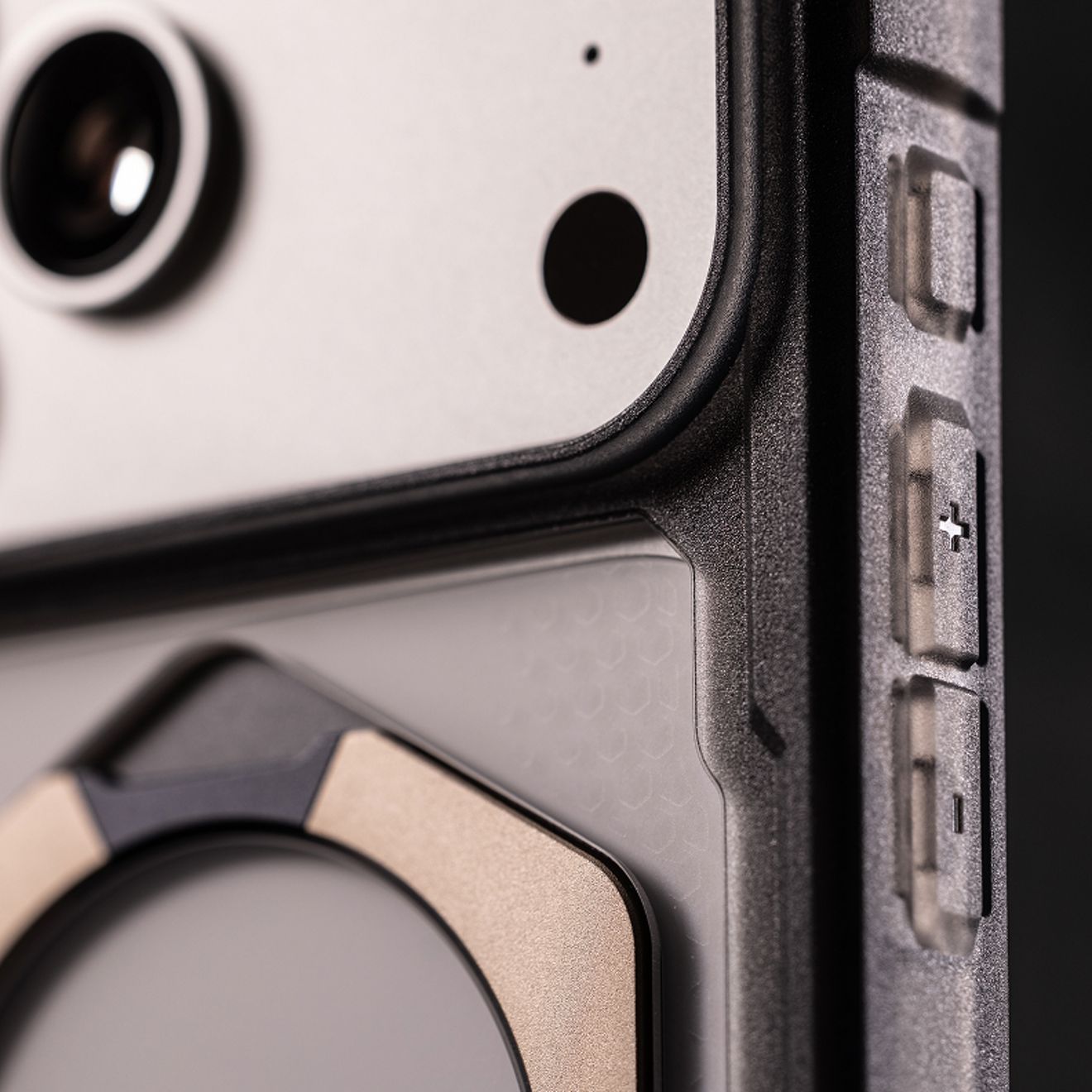 Close-up of an iPhone in a rugged UAG case, highlighting the raised camera protection, reinforced edge, and textured side buttons.
