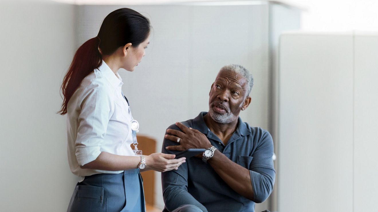 Healthcare professional consulting with a VA patient in a medical office.