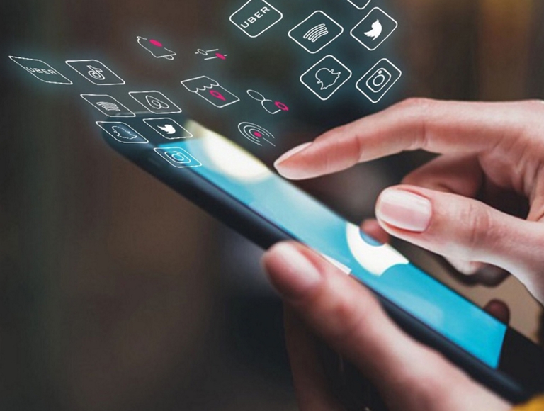 Close-up of a hand tapping a smartphone with app icons swirling about it