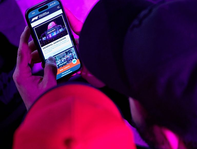 Someone holding up a phone showing the F1 Las Vegas app. 
