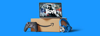 Una laptop con el programa de Amazon Prime The Boys en pantalla, apilada encima de una caja, con un mando de juegos y auriculares al lado de la caja.