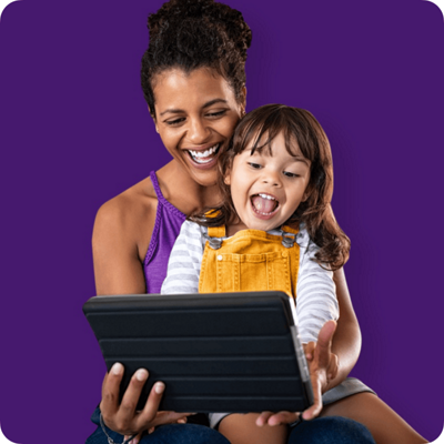 Mother and daughter looking at a tablet and smiling.