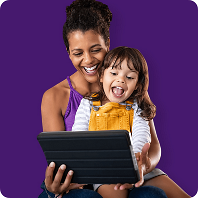 Madre e hija mirando una tablet y sonriendo.