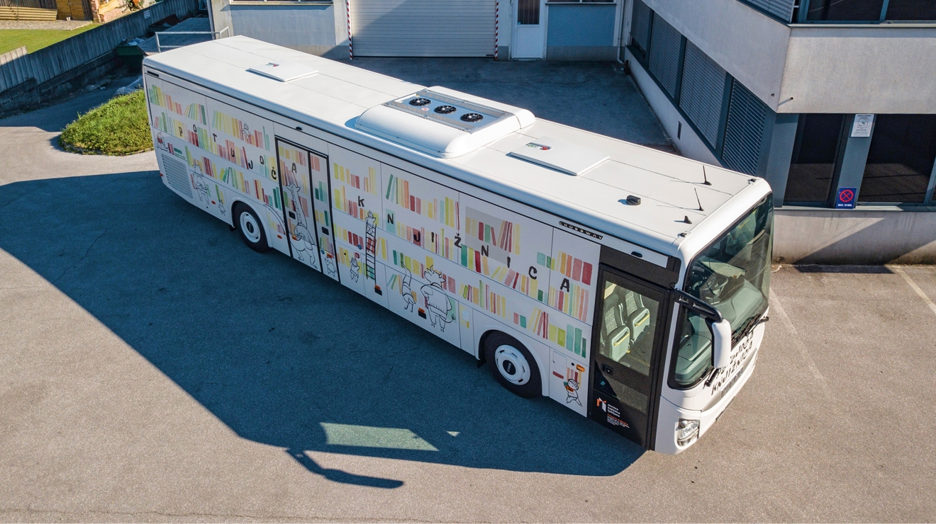 A connected bookmobile bus seen from above in a parking lot.