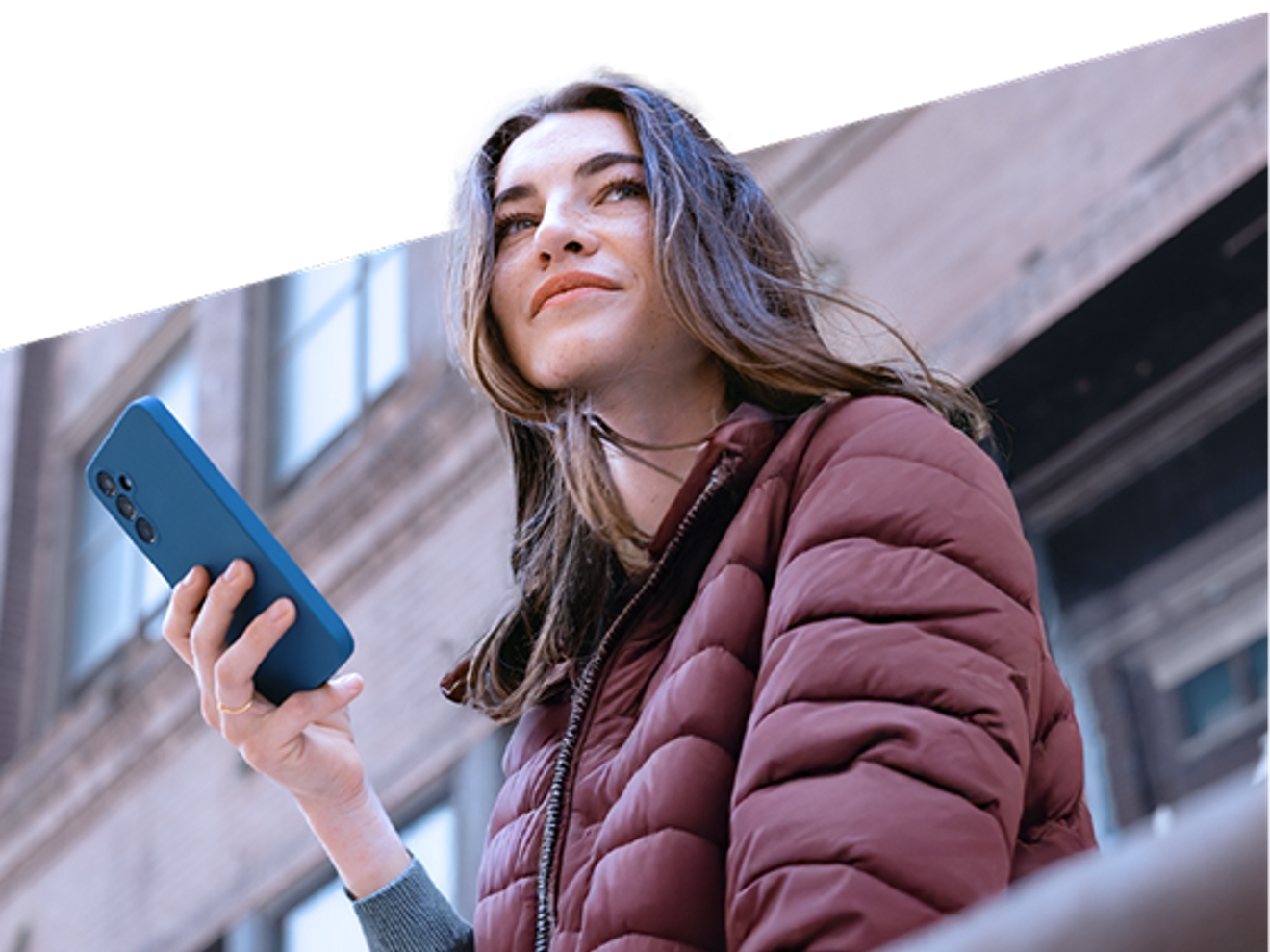 A woman looks at her smartphone.