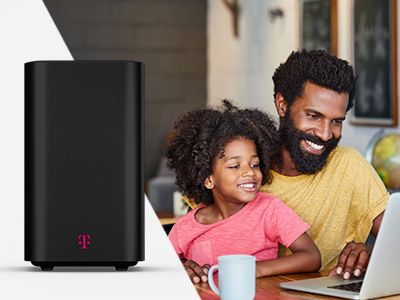 Dad and daughter on laptop with T-Mobile internet