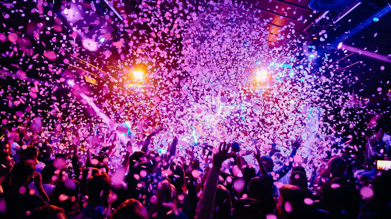 Concertgoers enjoy a light and confetti show.
