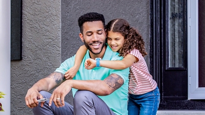 A parent and child looking at the SyncUP KIDS Watch together.