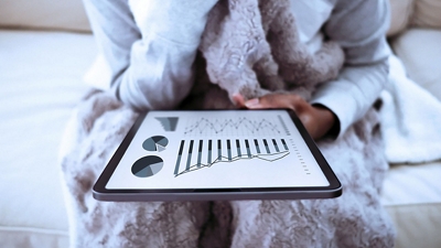 Woman relaxing in robe and looking at her tablet.