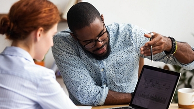 Two people reviewing scientific research data on a laptop