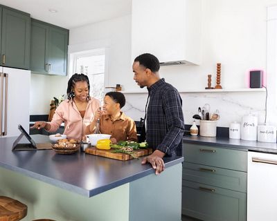 Family using a tablet while cooking in the kitchen.