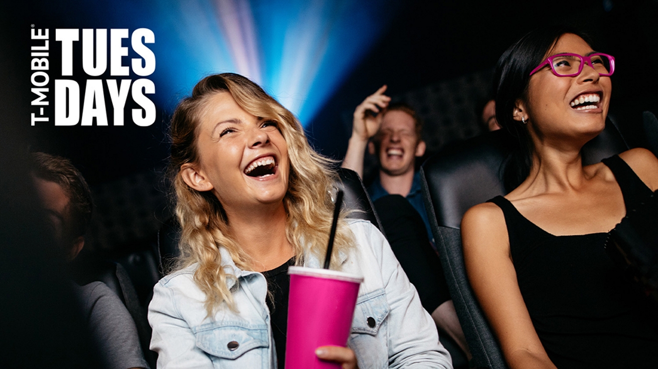 People laughing while watching a movie in a theater