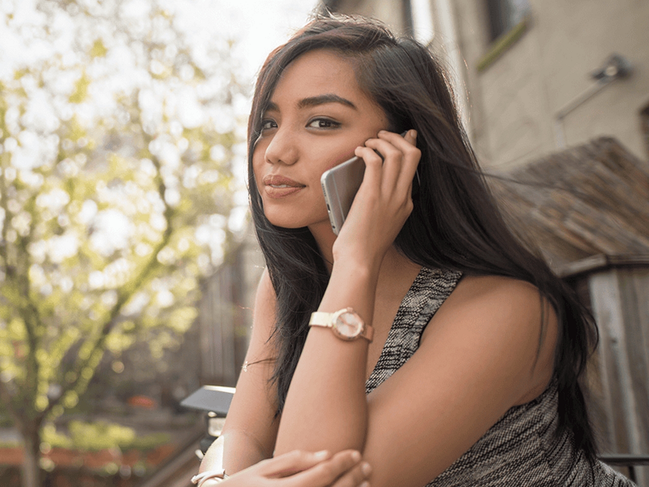 Young woman talking on her phone while outside.