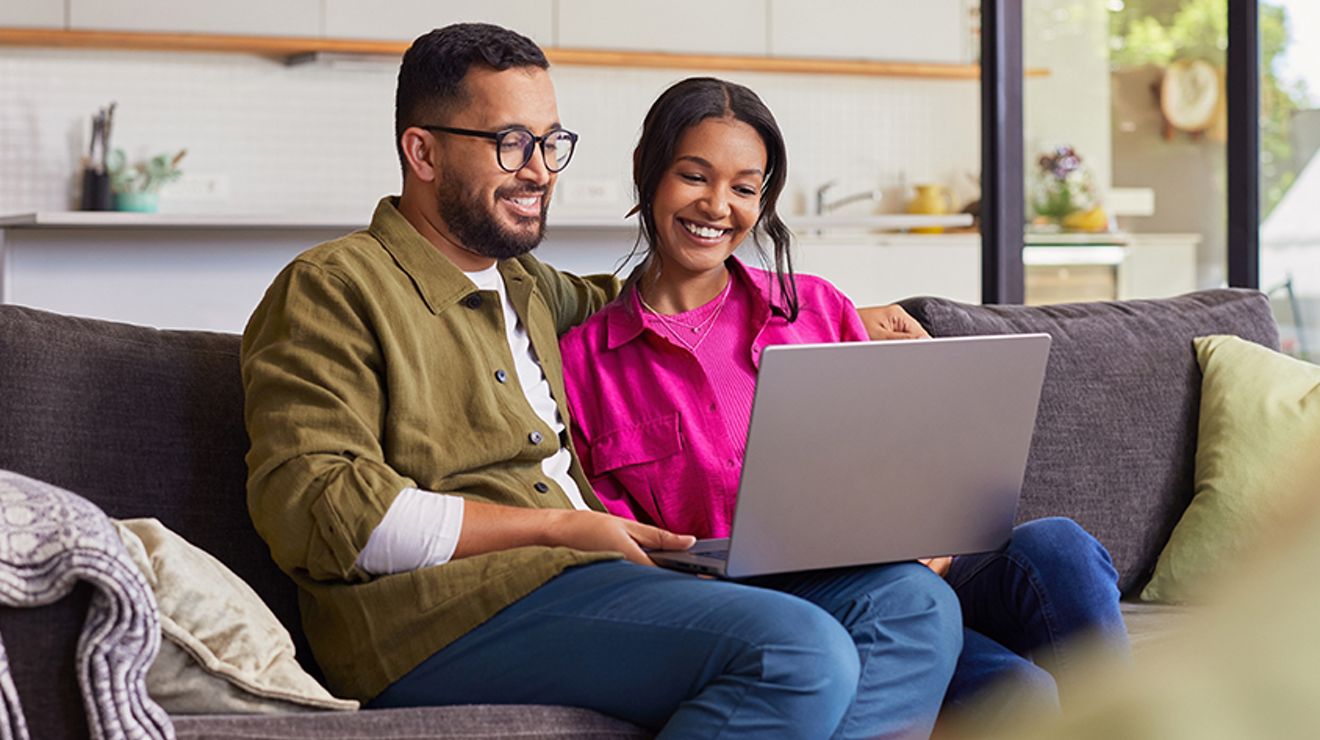 Couple using laptop at home.