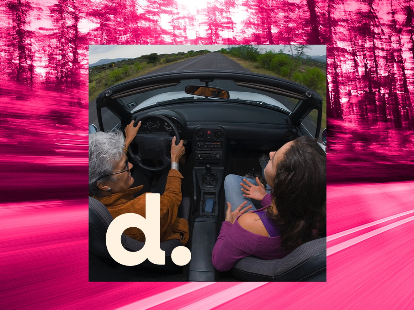 Vista desde el aire de dos amigos en un coche conduciendo por una carretera panorámica bordeada de árboles.