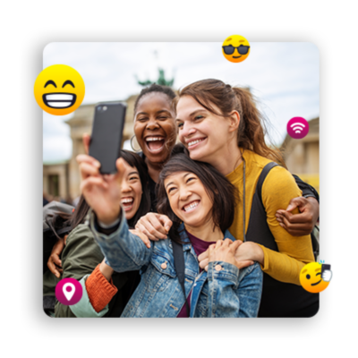 Four young women posing for a group selfie, surrounded by emojis.