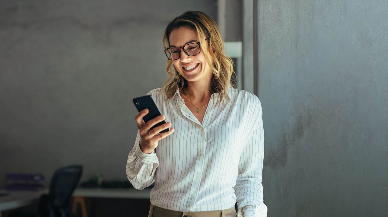Women smiling while looking at phone