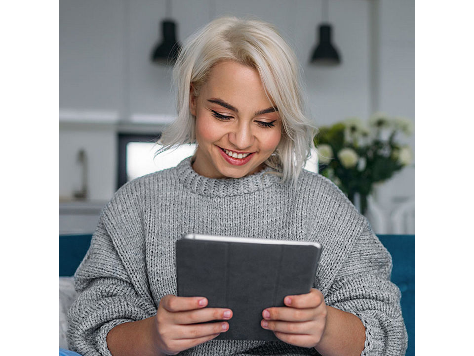 Woman smiling at her Ipad