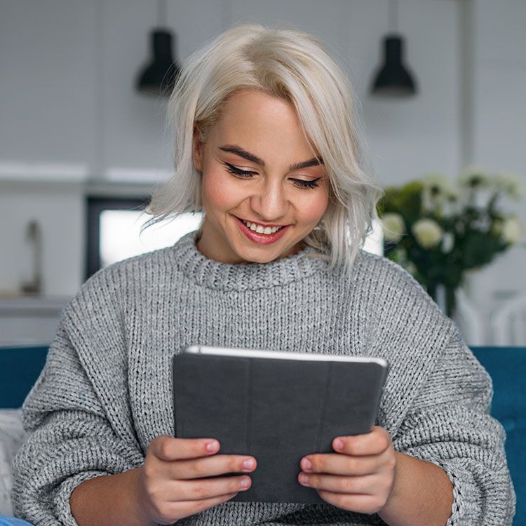 Woman smiling looking at her iPad.