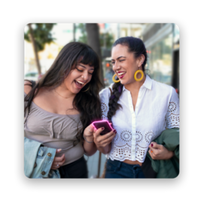 Two women smiling looking at phone.