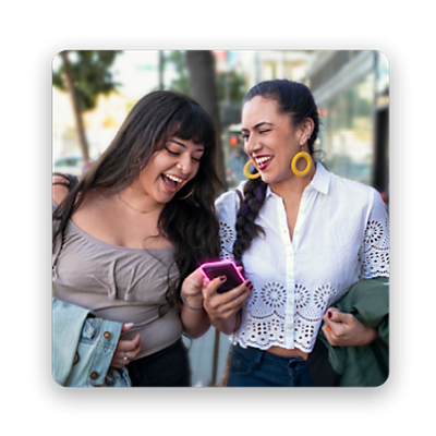 Two women smiling looking at phone. 
