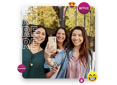 Three young women smiling. One holding up a phone.