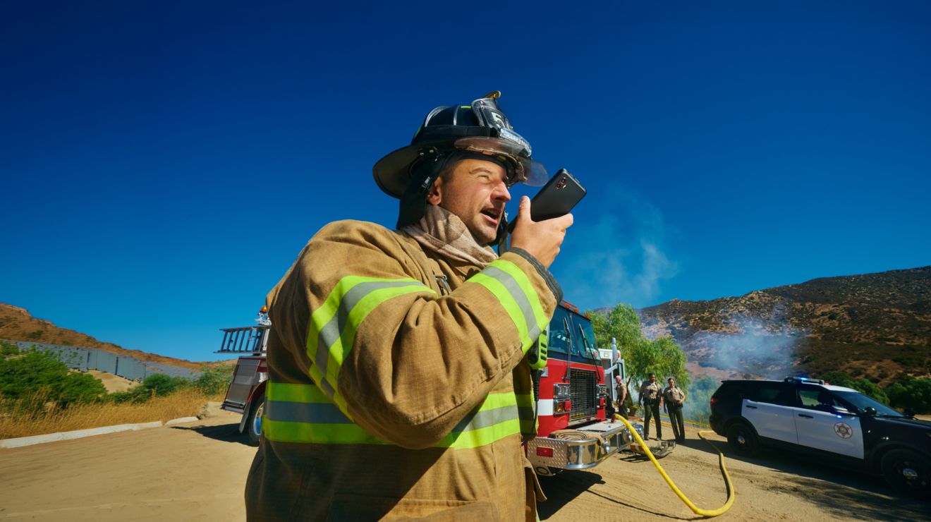 A firefighter connects over a secure smartphone from an incident scene at a rural location.